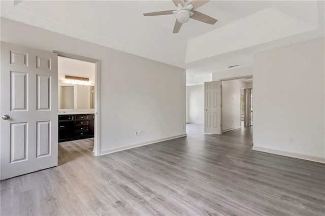 empty room with a ceiling fan, light wood-type flooring, and baseboards