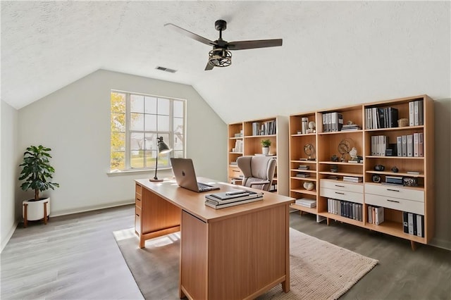 home office featuring ceiling fan, vaulted ceiling, a textured ceiling, and wood finished floors