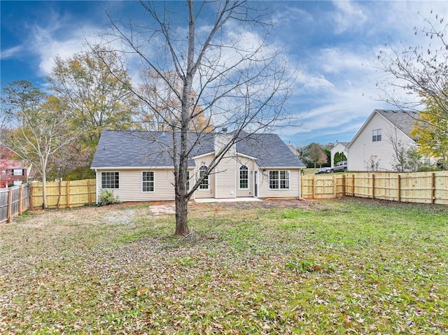 rear view of house with a yard and a fenced backyard