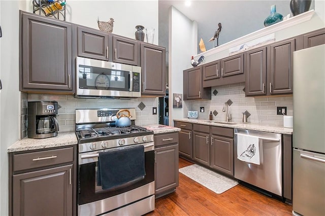 624 Spanish Oak Dr, Acworth, GA 30102 - kitchen with appliances with stainless steel finishes, wood finished floors, decorative backsplash, and a sink