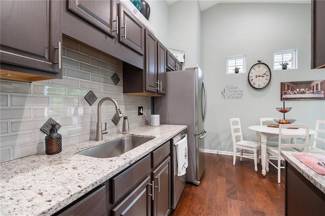 624 Spanish Oak Dr, Acworth, GA 30102 - kitchen with a sink, dark brown cabinetry, dark wood-type flooring, backsplash, and light stone counters