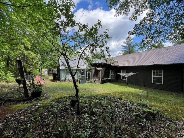 view of front of property with metal roof and a front lawn