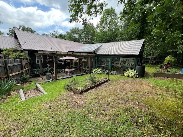 rear view of house with a vegetable garden and metal roof