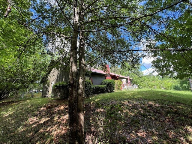 view of home's exterior featuring a yard and a chimney