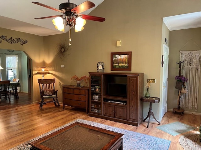 living room with a ceiling fan, baseboards, light wood-style flooring, and ornamental molding