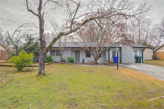 ranch-style house with brick siding, driveway, a chimney, and a front yard