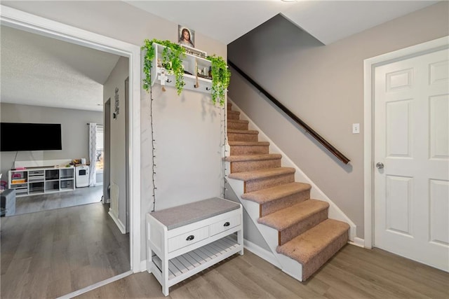 stairway with baseboards and wood finished floors