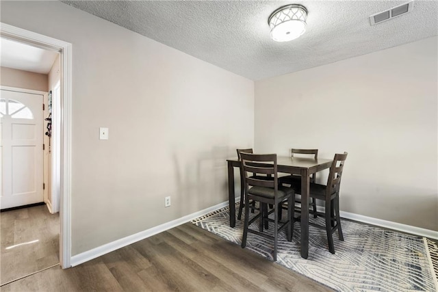 dining space with wood finished floors and baseboards