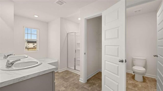 bathroom with walk in shower, vanity, and toilet