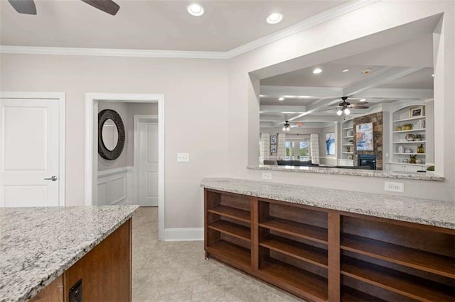 kitchen with crown molding, light stone countertops, coffered ceiling, and built in shelves