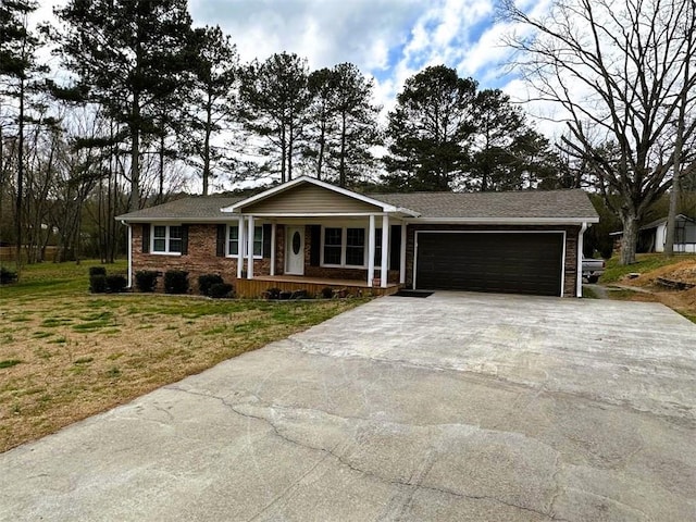 ranch-style home with brick siding, a porch, an attached garage, a front yard, and driveway