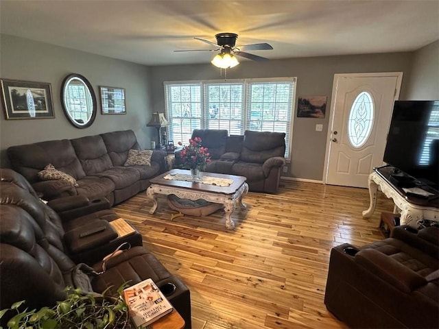 living room featuring a wealth of natural light, ceiling fan, baseboards, and hardwood / wood-style floors