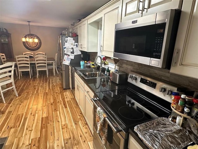 kitchen with dark countertops, light wood-type flooring, stainless steel appliances, and decorative backsplash