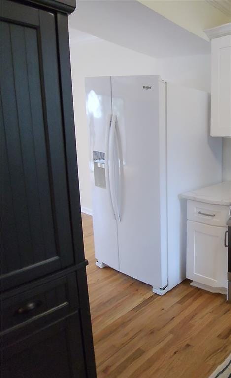 kitchen featuring white fridge with ice dispenser, white cabinetry, and light hardwood / wood-style flooring