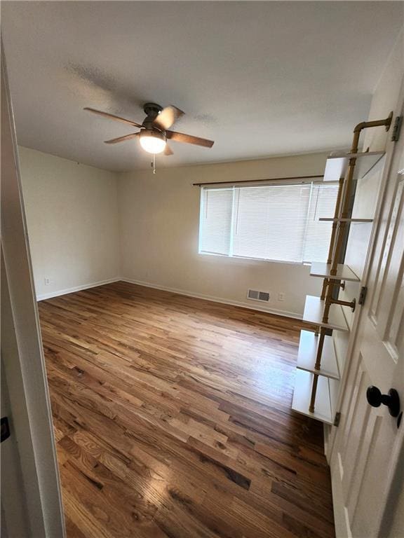 spare room with ceiling fan and dark wood-type flooring