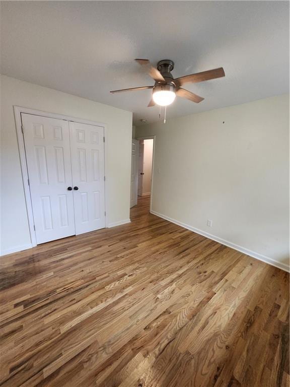 unfurnished bedroom with ceiling fan, light hardwood / wood-style floors, and a closet