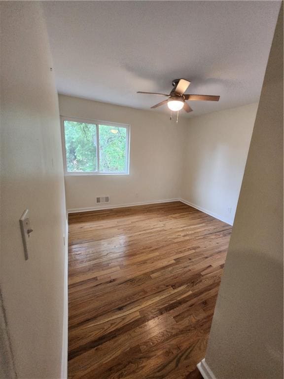 empty room with hardwood / wood-style flooring and ceiling fan