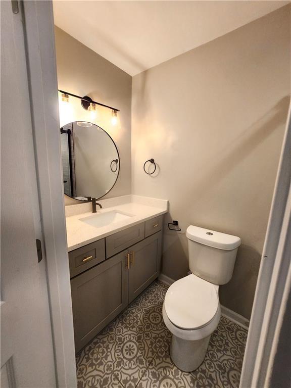 bathroom featuring toilet, tile patterned floors, and vanity