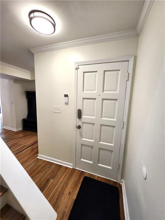 entryway with crown molding and hardwood / wood-style floors