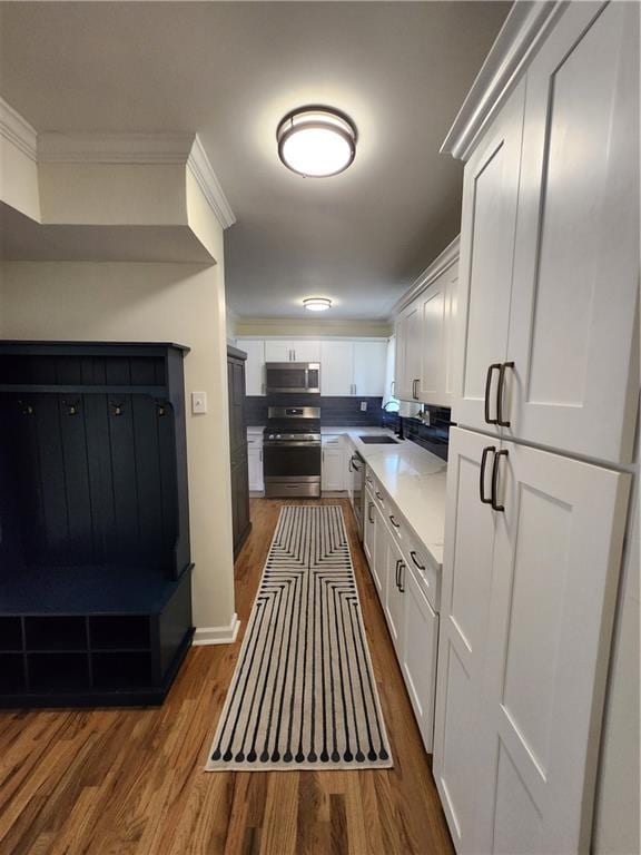 kitchen featuring sink, stainless steel appliances, dark wood-type flooring, and white cabinetry