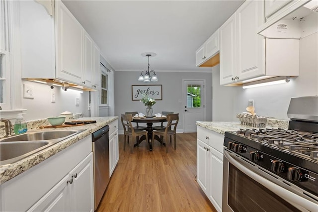kitchen with crown molding, a sink, under cabinet range hood, light wood-style floors, and stainless steel appliances