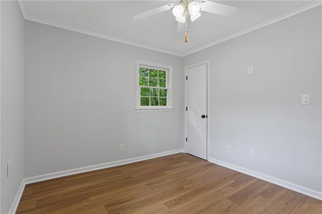 empty room featuring baseboards, ornamental molding, a ceiling fan, and wood finished floors