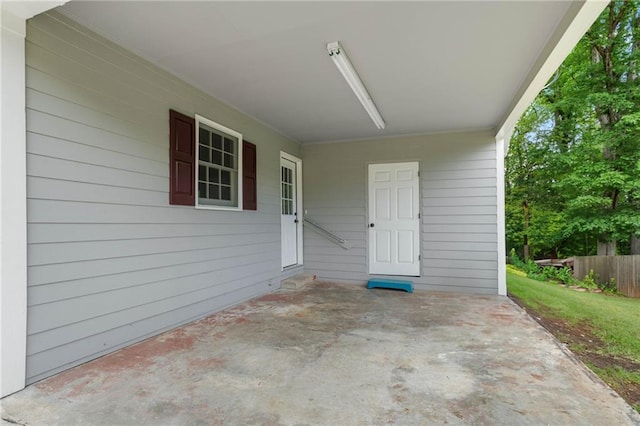 view of patio / terrace featuring fence and a carport
