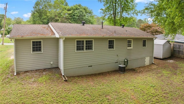 rear view of house featuring fence, central air condition unit, a shingled roof, crawl space, and a lawn