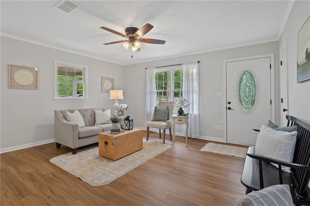 living area with a healthy amount of sunlight, a ceiling fan, wood finished floors, and visible vents