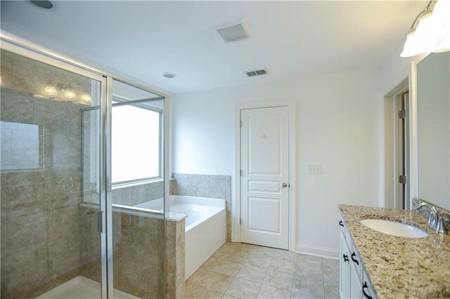 bathroom featuring plus walk in shower, vanity, and tile patterned floors