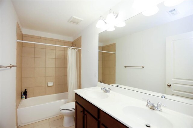 full bathroom featuring tile patterned floors, vanity, shower / tub combo with curtain, a notable chandelier, and toilet