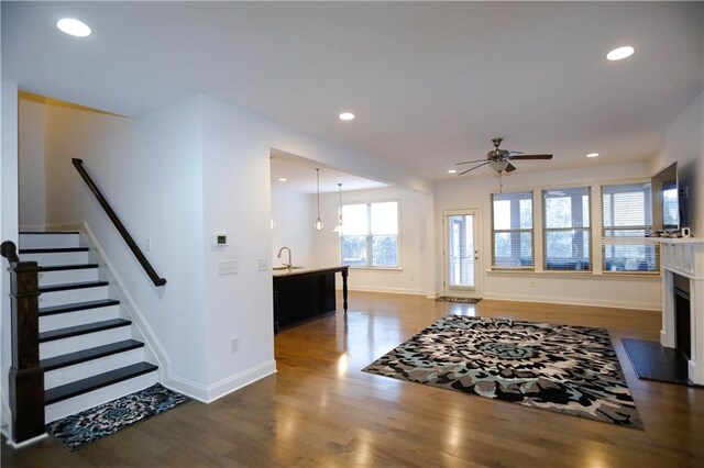 living room featuring ceiling fan, dark hardwood / wood-style flooring, and sink