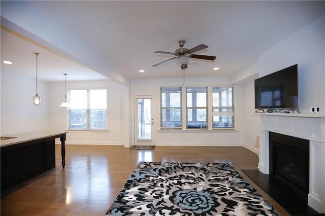 living room featuring ceiling fan and dark wood-type flooring