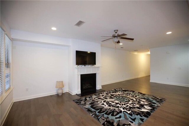 living room with ceiling fan and dark wood-type flooring