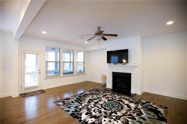 living room featuring ceiling fan and dark wood-type flooring