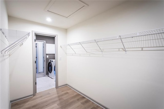 walk in closet featuring light wood-type flooring and washer and dryer