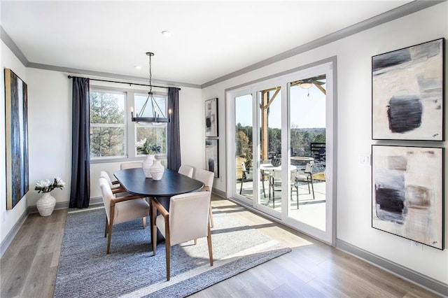 dining area with wood finished floors, a wealth of natural light, and crown molding