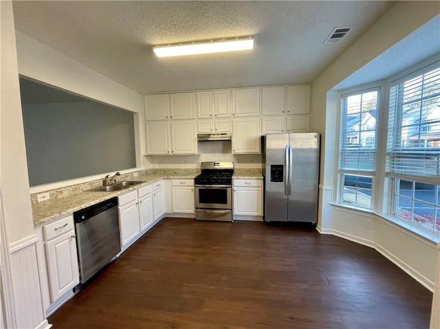 kitchen featuring sink, white cabinets, dark hardwood / wood-style flooring, stainless steel appliances, and a textured ceiling