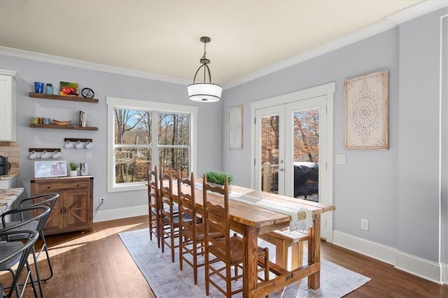 dining area with dark wood-type flooring and ornamental molding