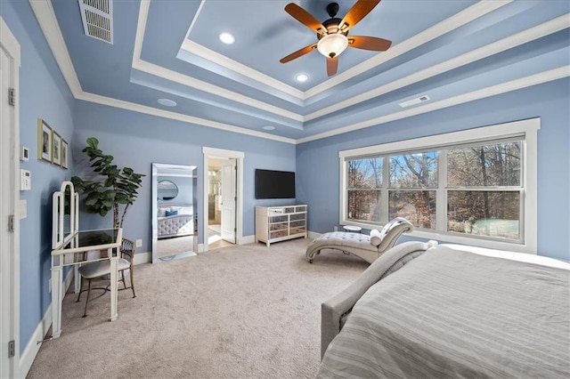 bedroom with a raised ceiling, ceiling fan, ornamental molding, connected bathroom, and carpet floors