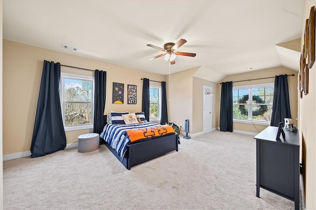 carpeted bedroom with multiple windows, ceiling fan, and lofted ceiling