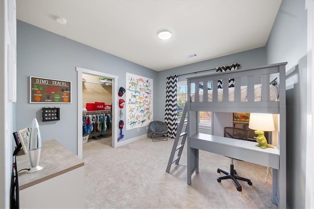 carpeted bedroom featuring a spacious closet and a closet