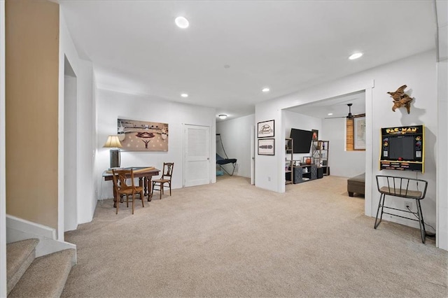 interior space with ceiling fan and light colored carpet