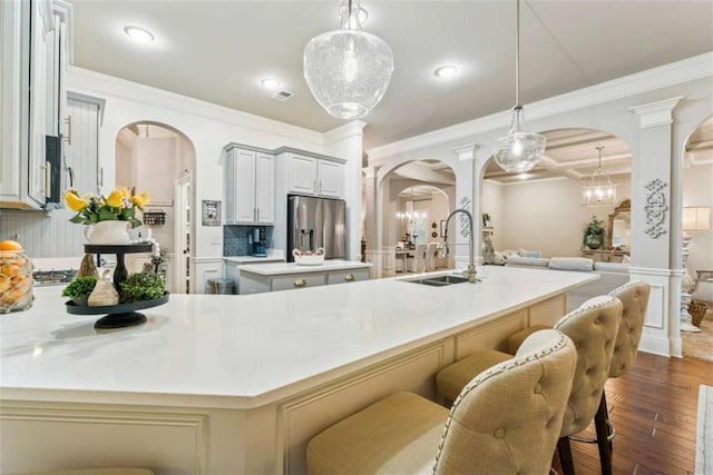 kitchen featuring a large island, arched walkways, light countertops, and pendant lighting