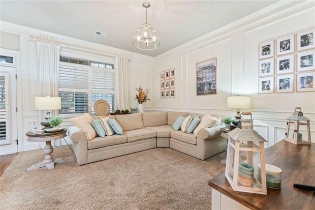 living area featuring ornamental molding, a notable chandelier, a decorative wall, and visible vents