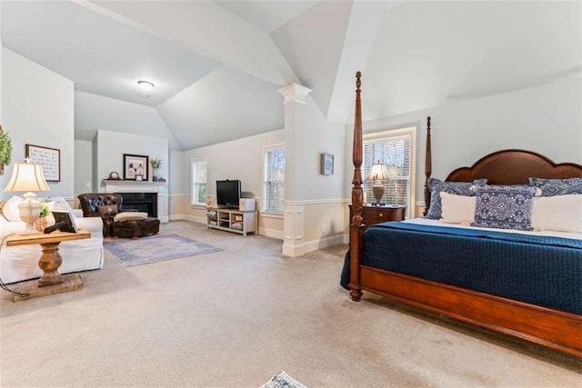 bedroom featuring lofted ceiling, carpet floors, a fireplace, baseboards, and ornate columns