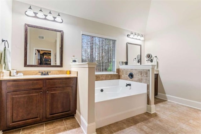 bathroom with a garden tub, visible vents, a spacious closet, vanity, and tile patterned floors