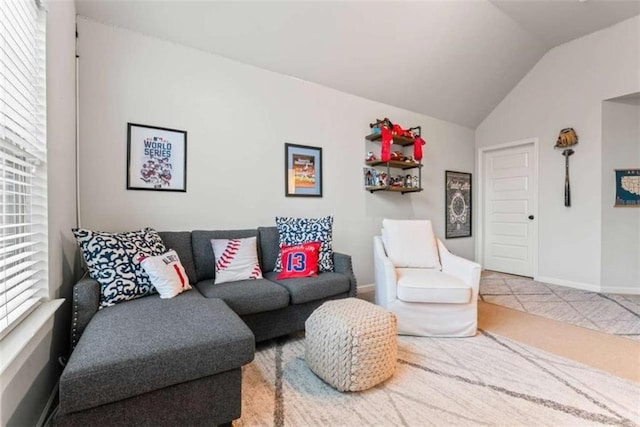 living area featuring lofted ceiling and baseboards