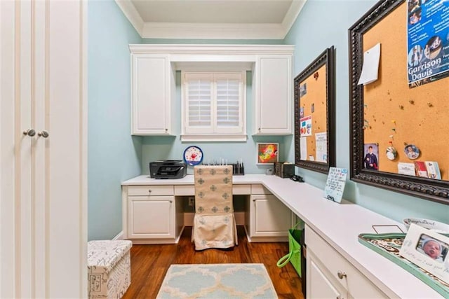 home office with dark wood-style floors, crown molding, and built in desk