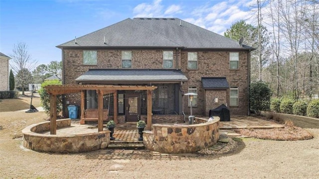 back of house featuring a patio, brick siding, and a shingled roof